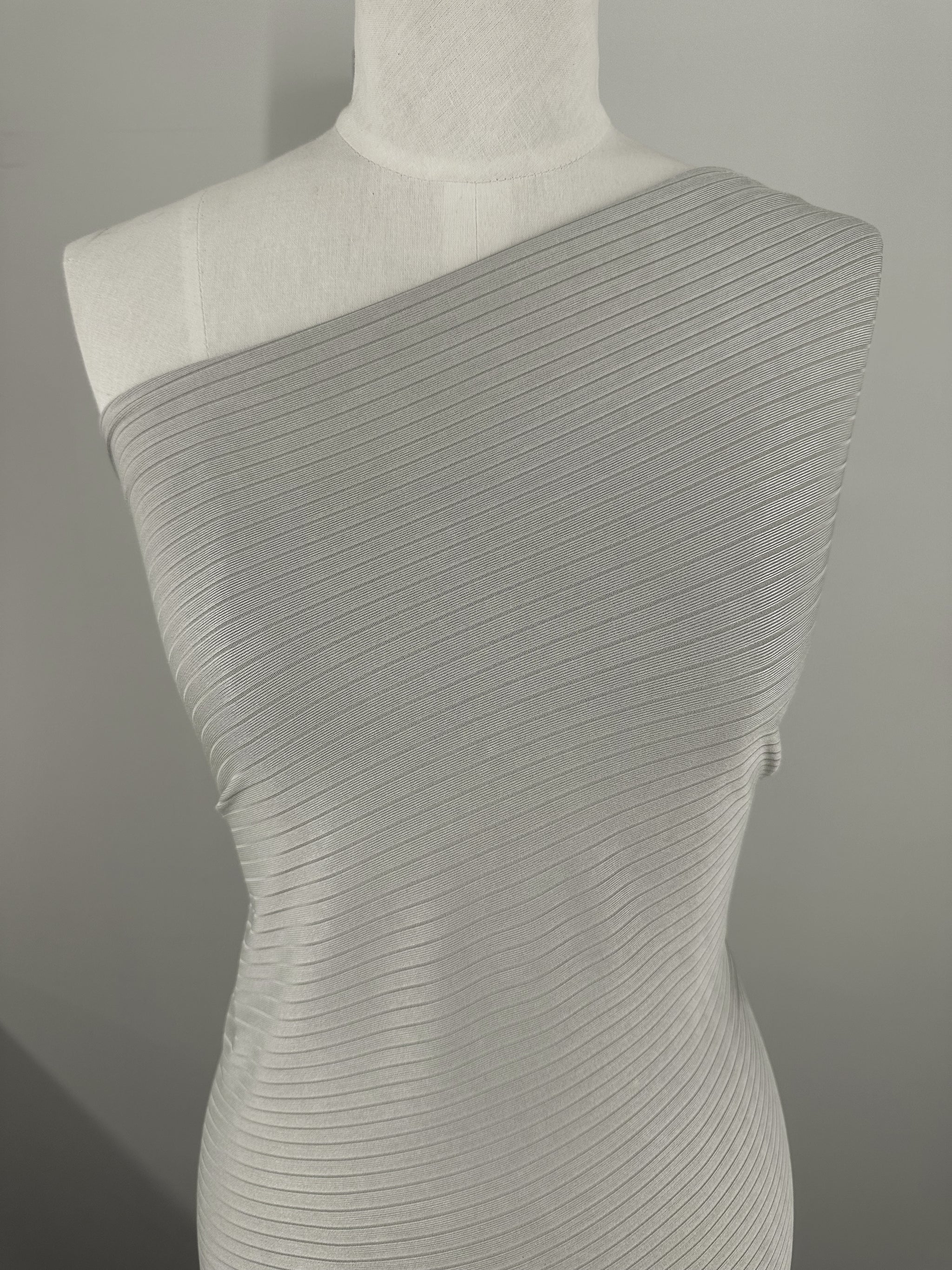 A mannequin features a sleeveless, one-shoulder design in medium weight Rib Knit - Grey - 175cm fabric by Super Cheap Fabrics with a subtle sheen and generous stretch, set against a plain gray background.