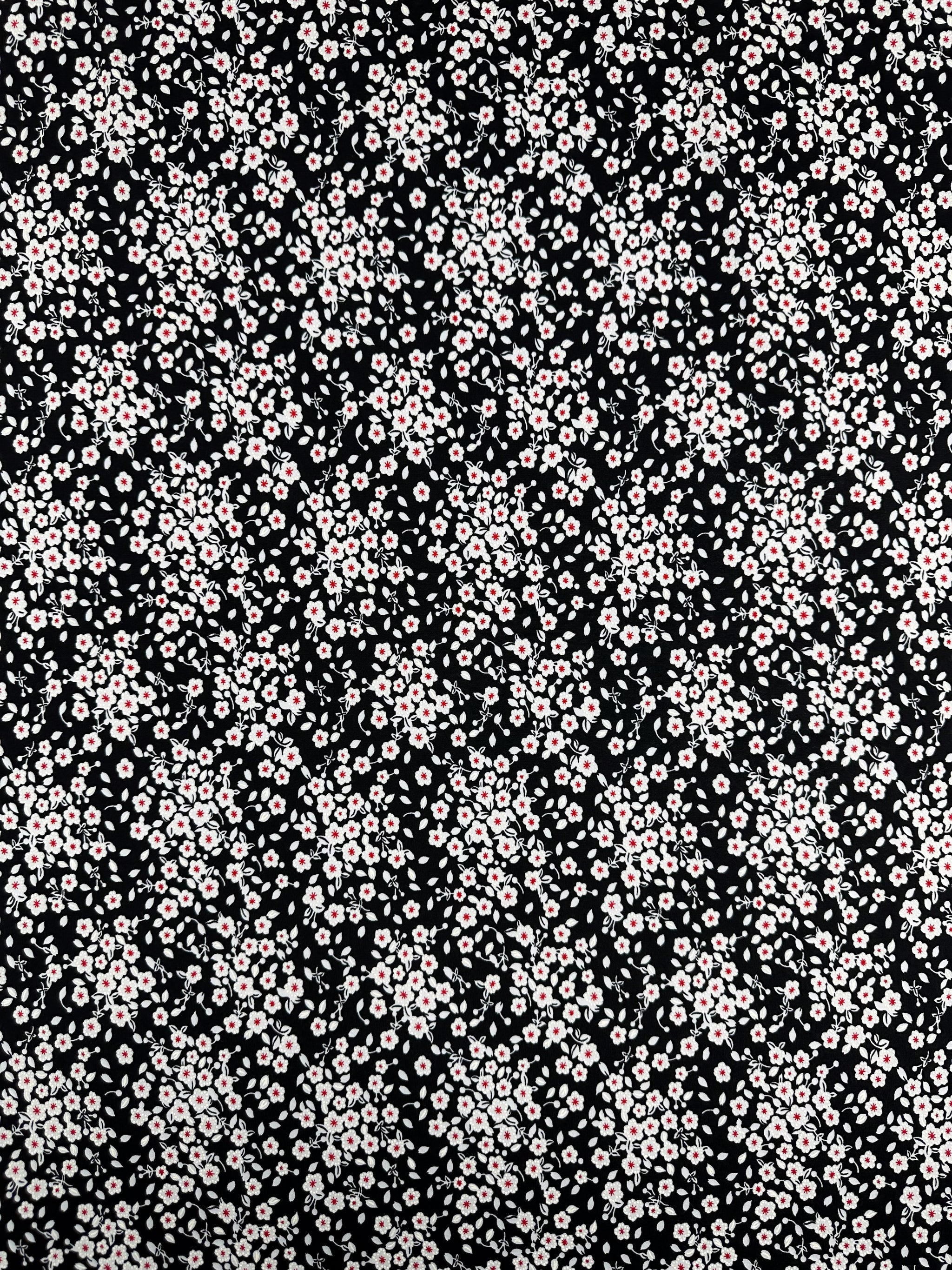 Textured Lycra - Sugar Pollen by Super Cheap Fabrics features small light pink and white flowers with green leaves on a black background, printed on medium weight polyester spandex, 150cm wide.