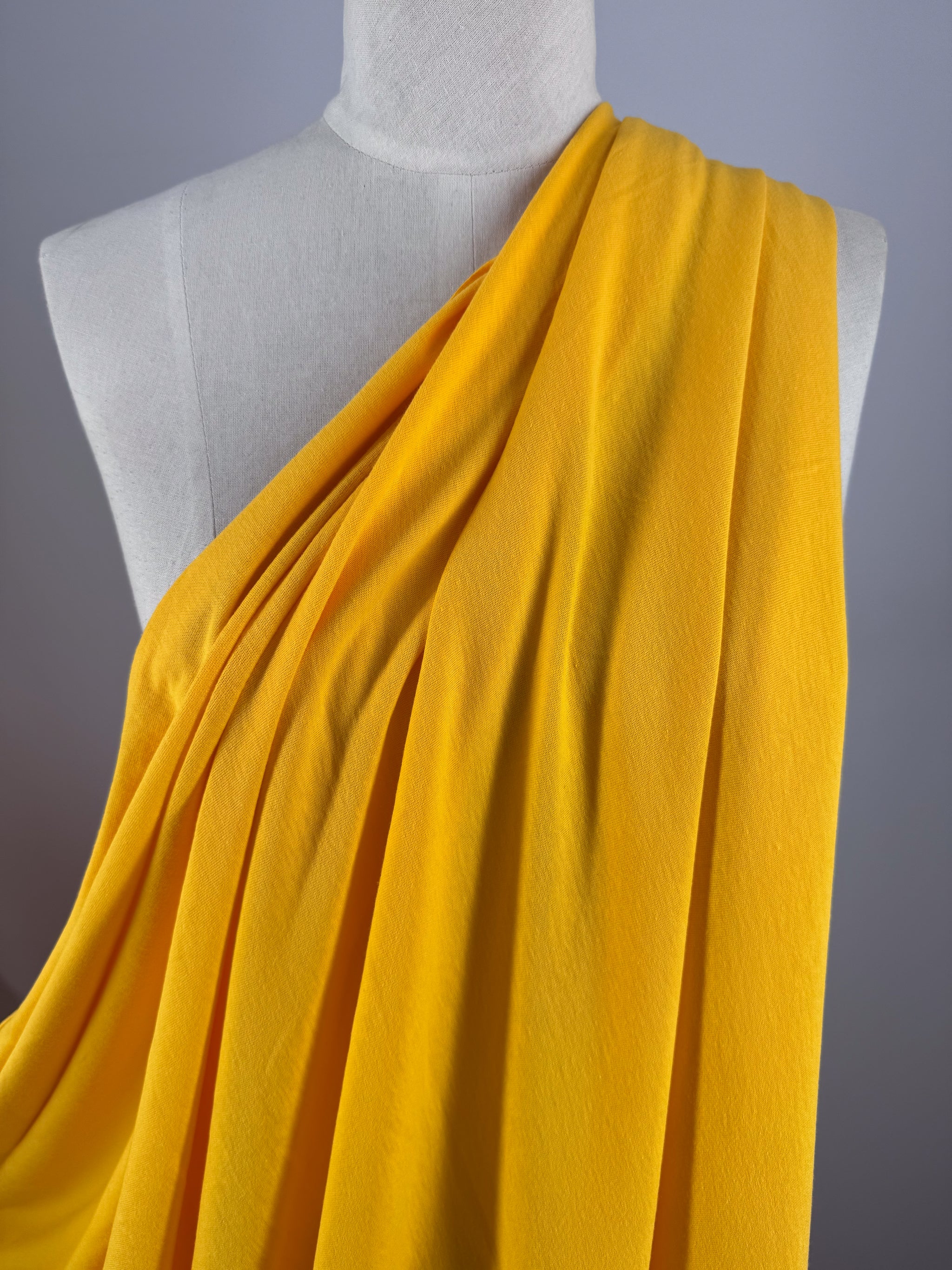 A mannequin elegantly wears a vibrant toga made of 